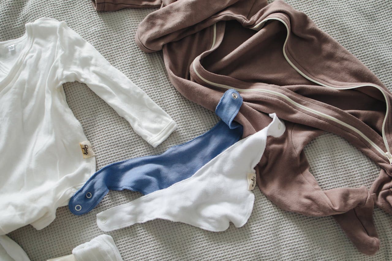 Roupas de bebês estendidas na cama